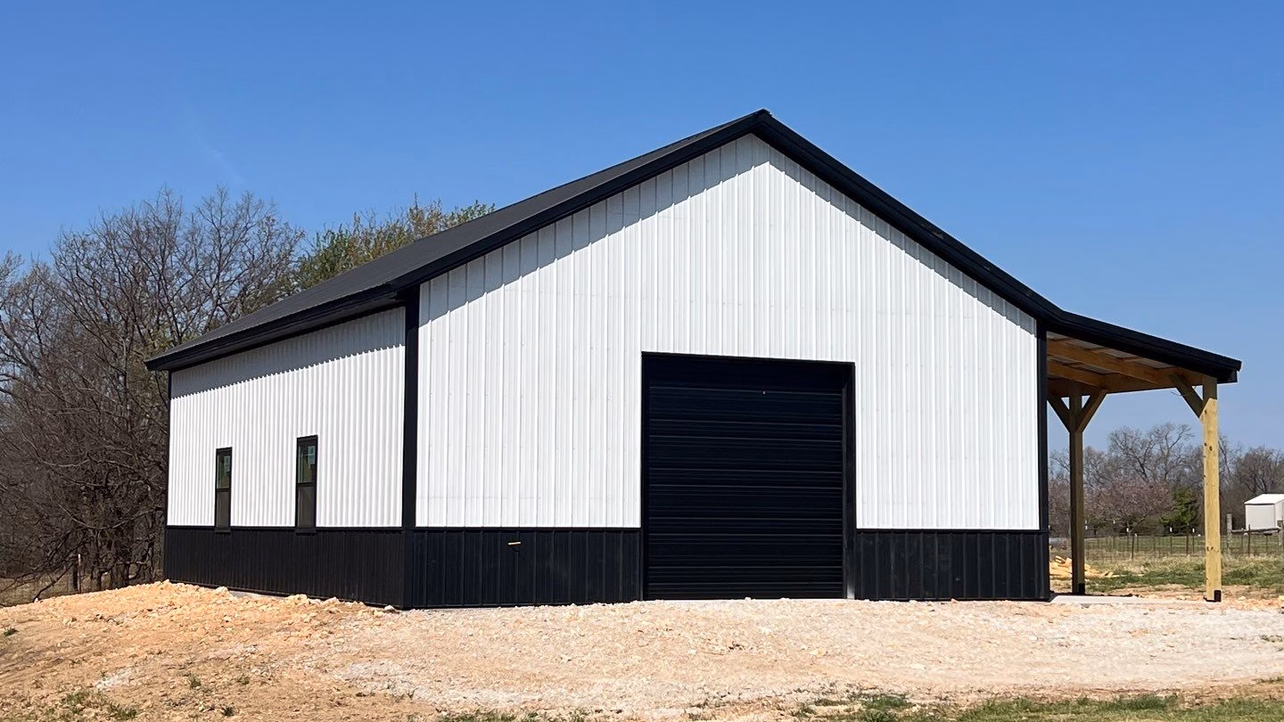 A classic black and white 30x40 detached garage in centerton, Arkansas with a 10' lean-to on the side.