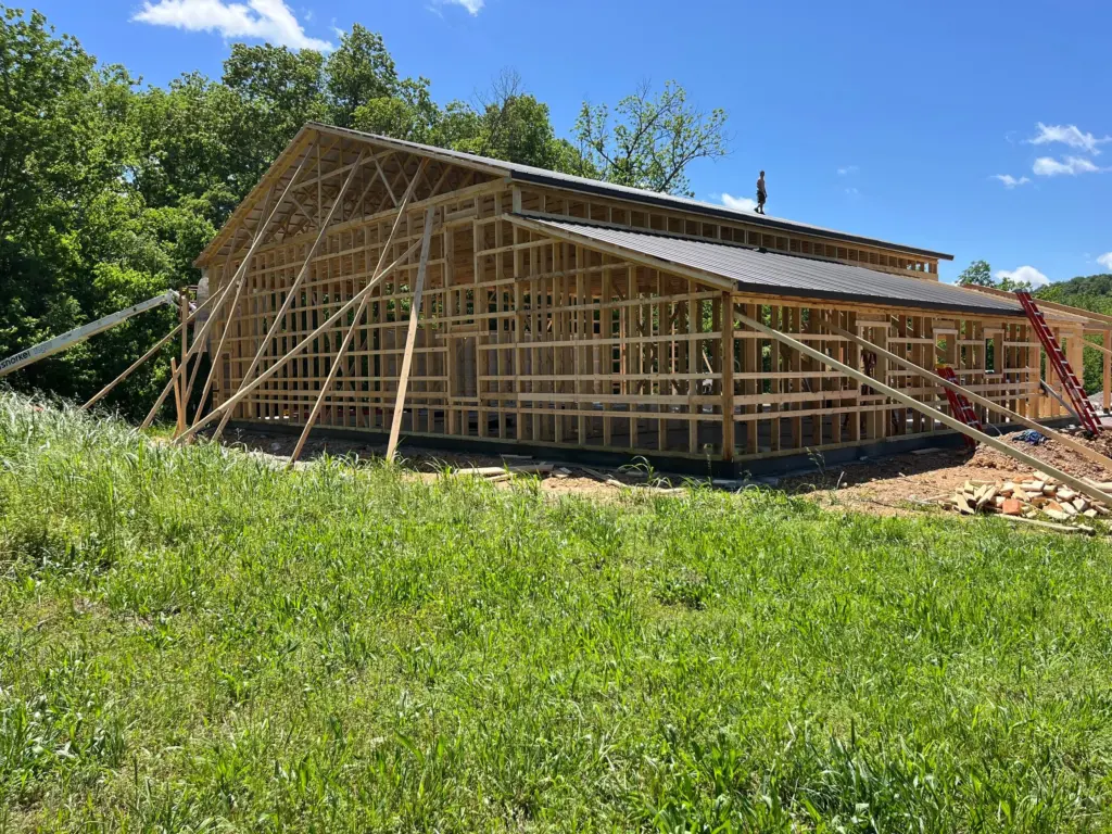 A large shop and house combo building under construction with roofing on and walls still being finished