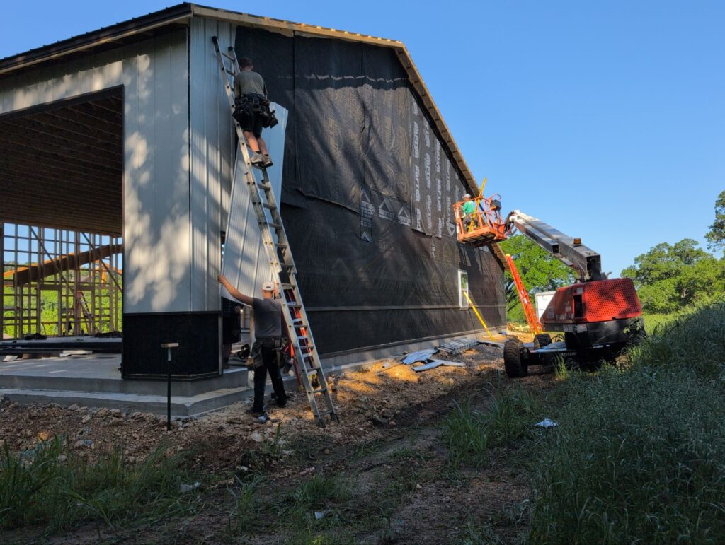 Yutzy construction adding metal to the walls of a large shop house project.