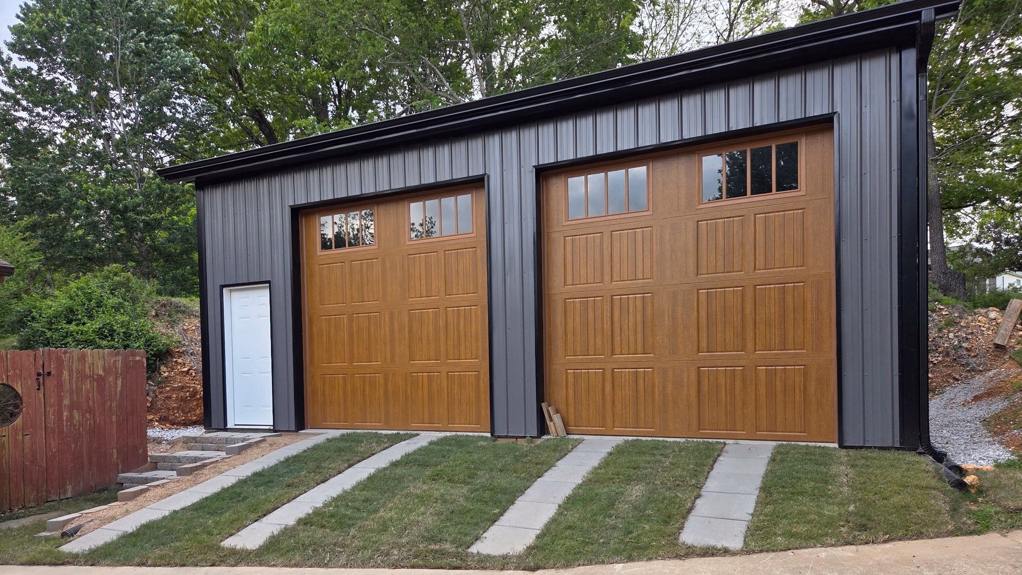 A nice custom garage in Rogers Arkansas with wood grain metal garage doors built by Yutzy construction