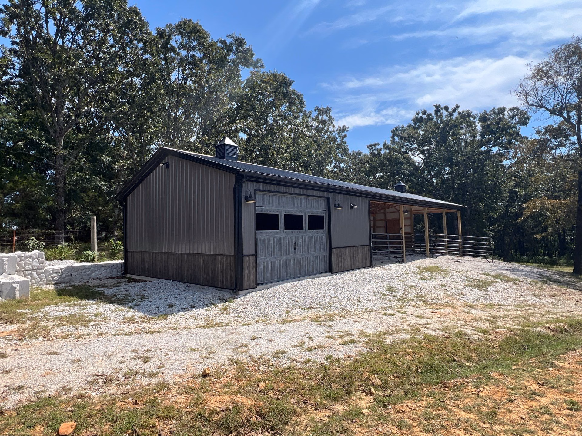 A beautiful metal building for a horse barn in northwest arkansas with a roll-up garage door and multiple stalls.